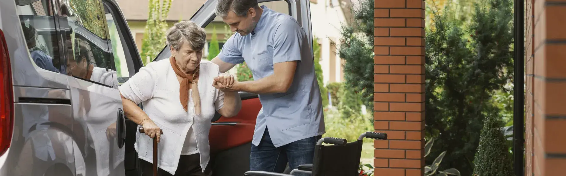 Caregiver accompanying senior citizen safely during vehicle transition